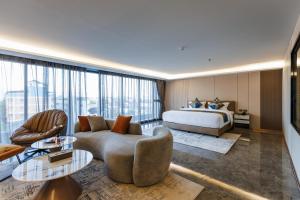 a hotel room with a bed and a couch and tables at Marquis Hotel in Ban Bang Toei (1) +48 photos