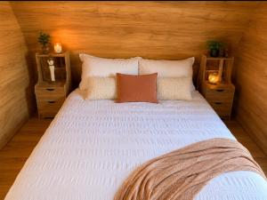a large white bed with pillows and two night stands at Kangaroo Island A-Frame Off-Grid Escape in Pelican Lagoon