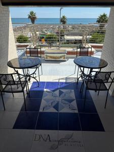 two tables and chairs on a patio with a view of the ocean at Afrodite Luxury Residence & Spa in Pescara