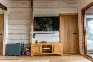 a room with a television on a wall with a table at The Larch House in Chester