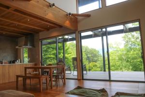 a kitchen and dining room with a table and chairs at お子さま連れ歓迎 森のやさしいサウナ付き一棟貸し -ご家族ご夫婦限定- in Komoro