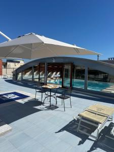 a patio with a table and chairs and an umbrella at Afrodite Luxury Residence & Spa in Pescara