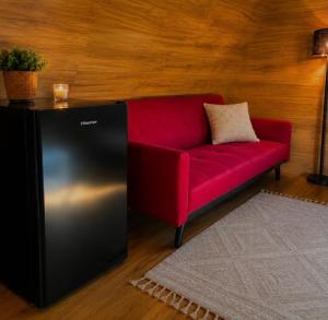 a red couch sitting in a room with a table at Kangaroo Island A-Frame Off-Grid Escape in Pelican Lagoon +23 photos