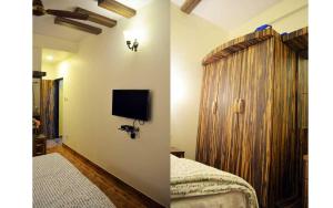 una camera da letto con un letto e una TV a parete di Nirvana Inn a Mahabaleshwar