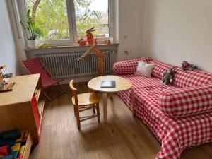 a living room with a red plaid couch and a table at Petit Fleur in Marktleuthen