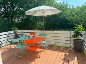 a table and chairs with an umbrella on a deck at Petit Fleur in Marktleuthen +5 photos