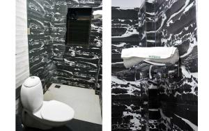 bagno con servizi igienici e parete in bianco e nero di Nirvana Inn a Mahabaleshwar