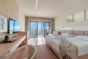 a hotel room with a large bed and a television at GRIFID Arabella Hotel - Ultra All inclusive & Aquapark in Golden Sands