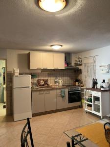 a kitchen with a white refrigerator and a table at Ferienhaus Vedran in Vir
