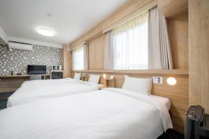 a hotel room with two beds and a television at Tabino Hotel EXpress Narita in Narita +67 photos