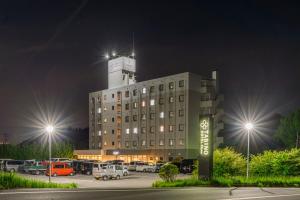 a hotel with cars parked in a parking lot at night at Tabino Hotel EXpress Narita in Narita