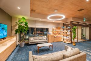 a living room with two couches and a tv at Tabino Hotel EXpress Narita in Narita