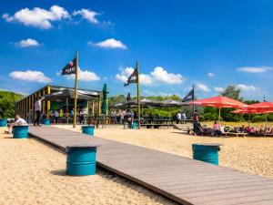a boardwalk on the beach with flags and a restaurant at Leipzig Garden Rooms - Near Lake & easy Parking in Leipzig