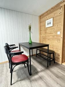 a table with two chairs and a vase on it at Little Flowerpot in Unterseen +29 photos