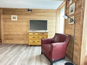 a living room with a chair and a television at Little Flowerpot in Unterseen