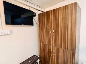 a wooden cabinet with a tv on a wall at Leo Stays in Bangalore