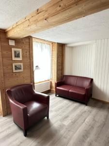 a living room with two leather chairs and a window at Little Flowerpot in Unterseen