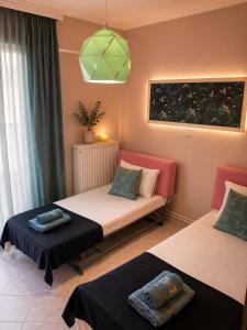 a bedroom with two beds and a green light at KilkisLuxuryApartment in Kilkis