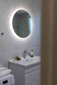 a white bathroom with a sink and a mirror at Elaya Experience in Kamisianá +61 photos