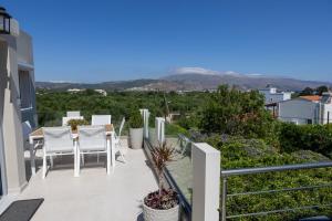 a balcony with white chairs and a table with a view at Elaya Experience in Kamisianá