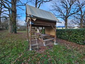 a dog house with a ladder in the grass at Camping Onlycamp Veuzain-sur-Loire in Veuzain-sur-Loire