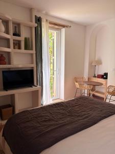 a bedroom with a bed and a table and a window at Clos Lujatis in Valençay