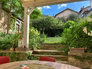 a patio with a table and chairs in a garden at Maison Romane 1136 in Cluny