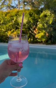 a person holding a glass with a pink drink at La Parenthèse de Villepey in Saint-Aygulf