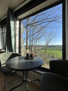 a room with a table and a large window at Domaine de Meros in Plonévez-du-Faou