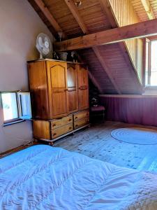 a bedroom with a large bed and a wooden dresser at Gîte FRAIZE in Fraize