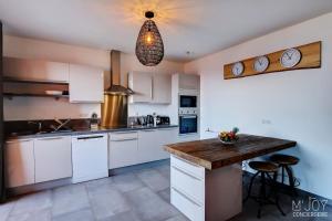 a kitchen with white cabinets and a wooden counter top at PAPANG - House 148m 3rooms Jacuzzi in Saint-Leu