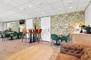 a living room with a couch and a table and chairs at Guesthouse Ouddorp Connection in Ouddorp