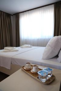 a hotel room with a bed with a tray with tea cups at Mudanya Yıldız Otel in Mudanya