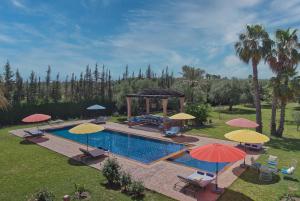 an image of a swimming pool with umbrellas at Domaine 3 Riads in Marrakesh
