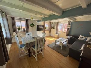 a living room with a table and a couch at Dat Lütte Huus - Ferienhaus nahe Greetsiel in Krummhörn
