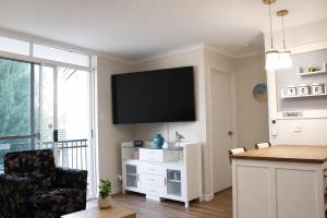 a living room with a flat screen tv on a wall at Sea Breeze Apartment in Mandurah +3 photos