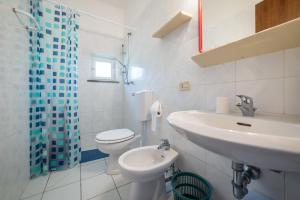 a white bathroom with a sink and a toilet at Acqua e Sale in Pomonte +9 photos