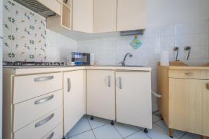 a kitchen with white cabinets and a sink at Acqua e Sale in Pomonte