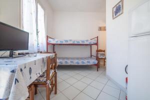 a living room with a tv and a table with a television at Acqua e Sale in Pomonte