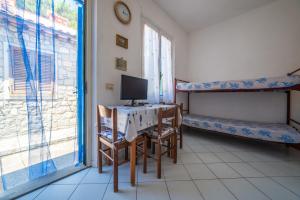 a room with a desk with a computer and a bed at Acqua e Sale in Pomonte