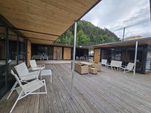 a deck with white chairs and tables on a building at Ponton Plutitor New Life in Bicaz