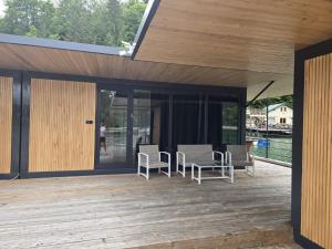 a patio with chairs and tables on a wooden deck at Ponton Plutitor New Life in Bicaz