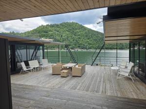 a wooden deck with chairs and a table on a boat at Ponton Plutitor New Life in Bicaz +30 photos