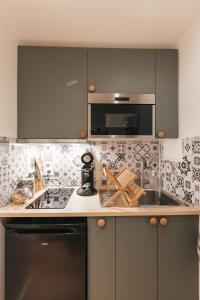 a kitchen with a sink and a counter top at Chez Gabriel et Sophie in Pérouges