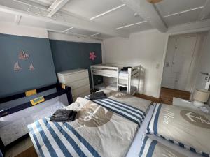 a bedroom with two beds and a desk in it at Dat Lütte Huus - Ferienhaus nahe Greetsiel in Krummhörn
