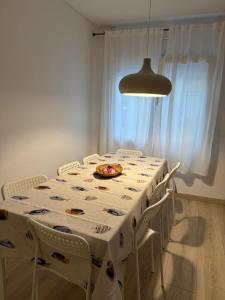 a white table with chairs and a plate of food on it at Can Julián in L'Escala