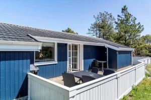 a blue house with a deck with chairs at 329-Thisted-Sandtornvej-21 in Thisted