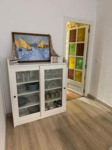 a white cabinet in a room with a painting at Can Julián in L'Escala