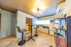 a kitchen with two chairs and a table in a room at Lax奈良Annex in Mitsugarasuchō
