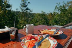 a table with two plates of food and fruit on it at Tetebatu Fullmoon in Tetebatu